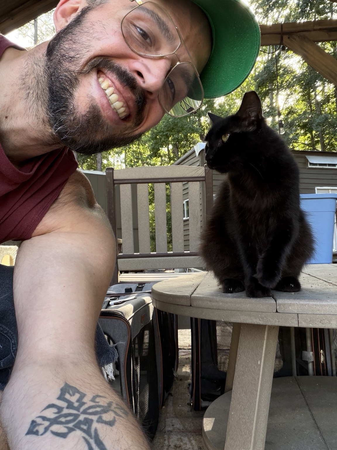 Craig Heun smiling outside with a black cat